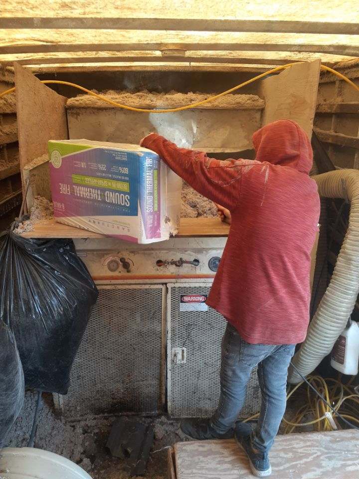 Employee loading Hopper for blown in insulation.