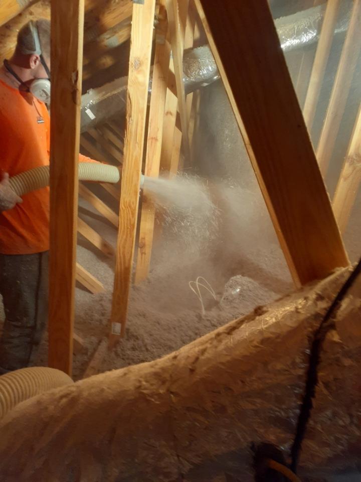 Employee spraying Cellulose in attic.